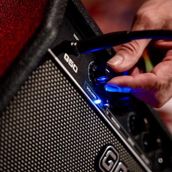 close up of a person adjusting the settings on a GAMMA G50 Guitar Amplifier