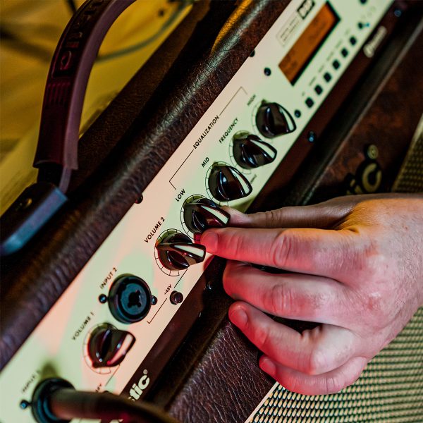 close up of a person adjusting the setting of A40 40W acoustic amp