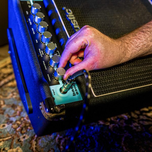 a person adjusting the B25C combo bass amp control panel settings