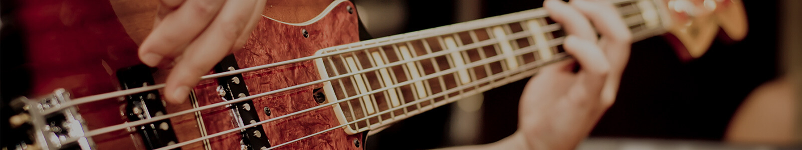 close up view of a bass guitar played by a man in the room