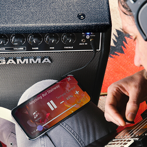 guitar player using phone with GAMMA G25 electric guitar amp with Bluetooth