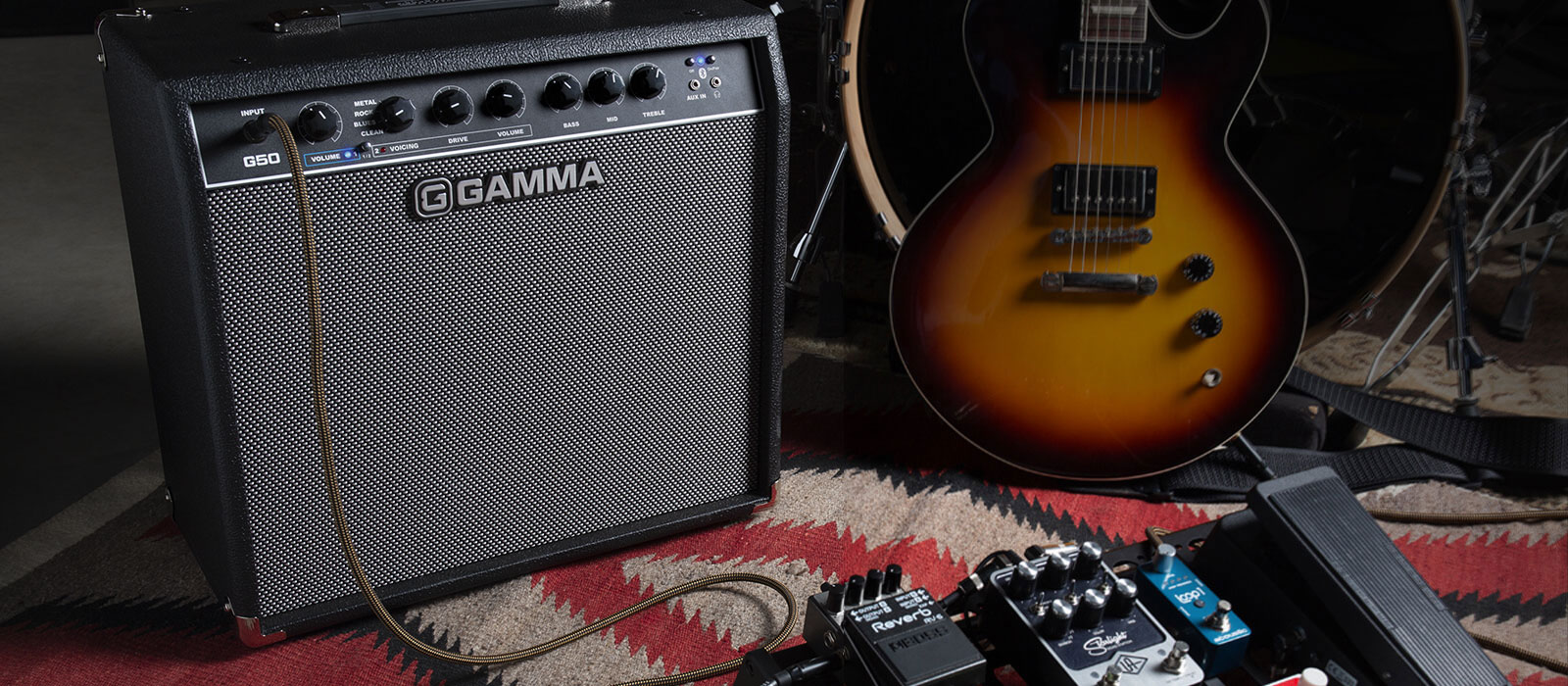 Gamma G50 guitar amp next to pedalboard, drums, and guitar