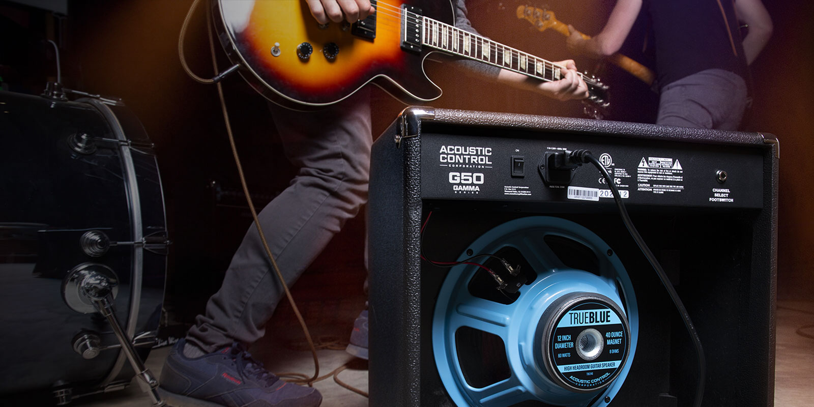 GAMMA G50 guitar amp on stage with performing band. The back of the amp is exposed, showing the bright blue 12