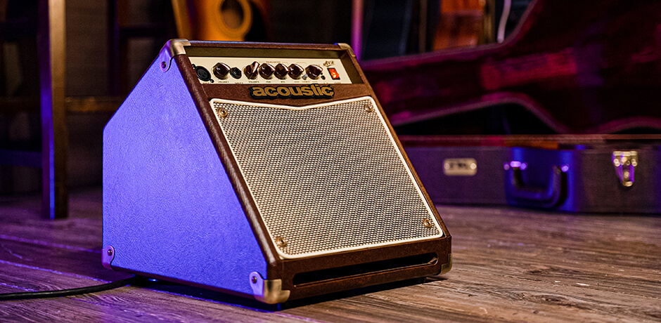 A15V 15 Watt acoustic instrument amp in front of an open acoustic guitar case