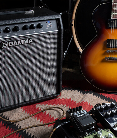 Gamma G50 guitar amp next to pedalboard, drums, and guitar