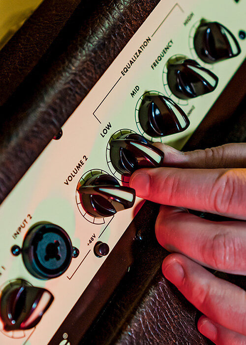close up of a person adjusting the equalizer of A40 40W acoustic amp