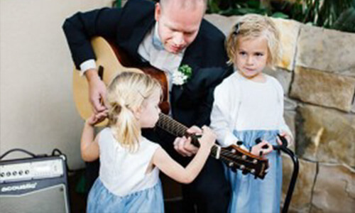 two kids interfering a person playing guitar in a wedding with acoustic A40 amp