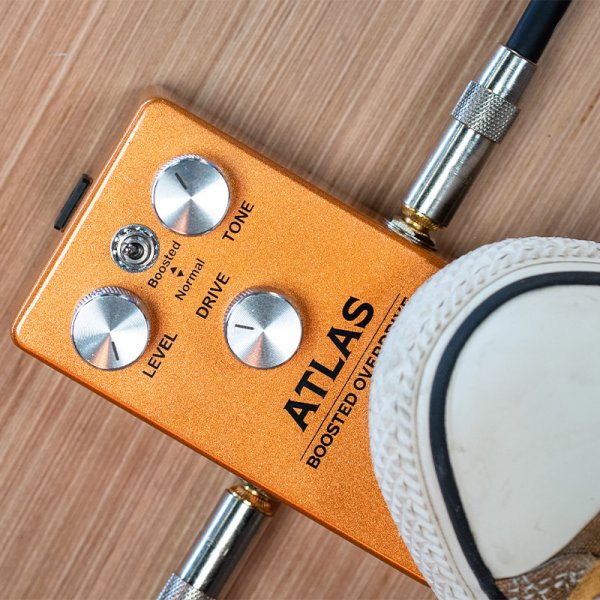 Gamma Atlas boosted overdrive pedal on the floor with a foot stepped on.