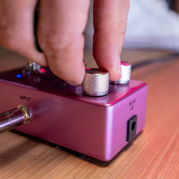 Gamma Eros clean chorus pedal on the floor with hand adjusting.