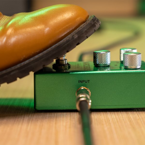 Gamma Narcissus warm delay pedal on the floor with a foot stepped on.